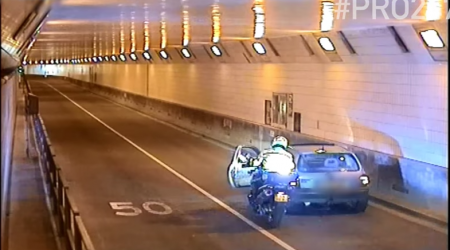 Motoragent Piet Kats duwt auto uit Maastunnel