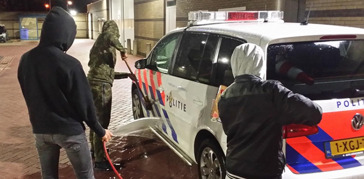 Dansende jongens wassen voor straf politiewagens
