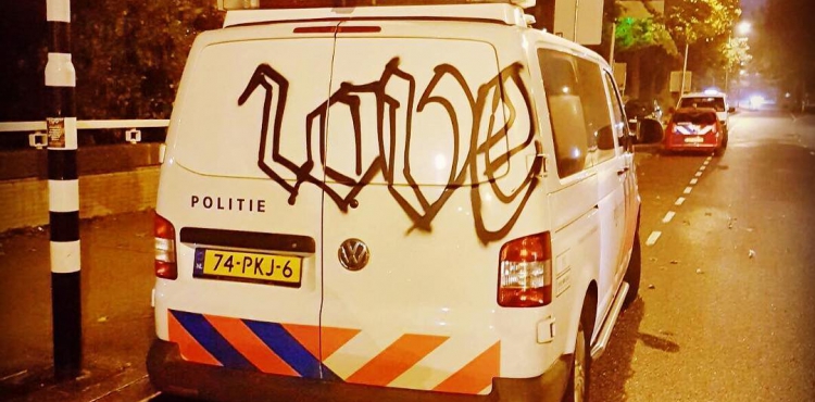 Vandalen spuiten graffiti op politiewagen tijdens incident